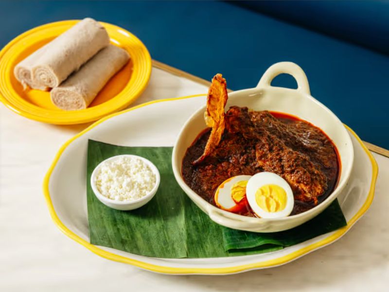 Rich red stew with hard-boiled egg, ayib, and injera