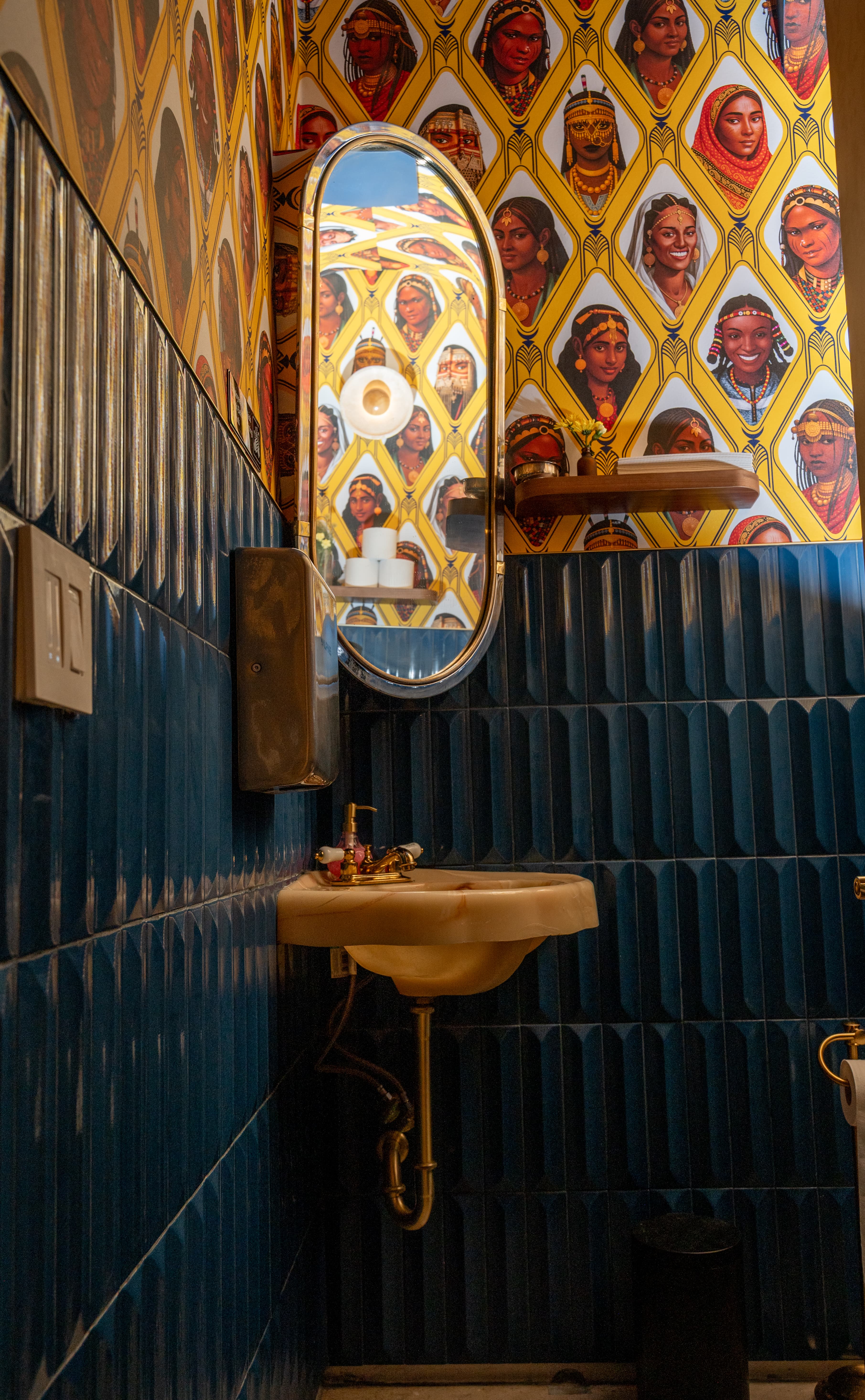 Makina bathroom with vibrant tiled wall and a potted plant